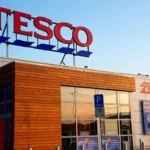 Front of a tesco store with a logo on top of it.