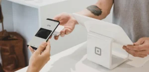 Someone paying with their phone at a cashier