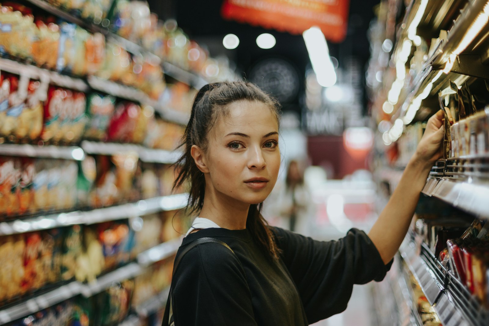 Mitarbeiterin von ALDI räumt Regale im Supermarkt ein