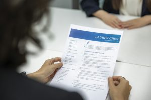 Personne rédigeant son CV pour postuler à un emploi en France
