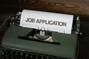 Candidat préparant sa lettre de motivation sur un ordinateur